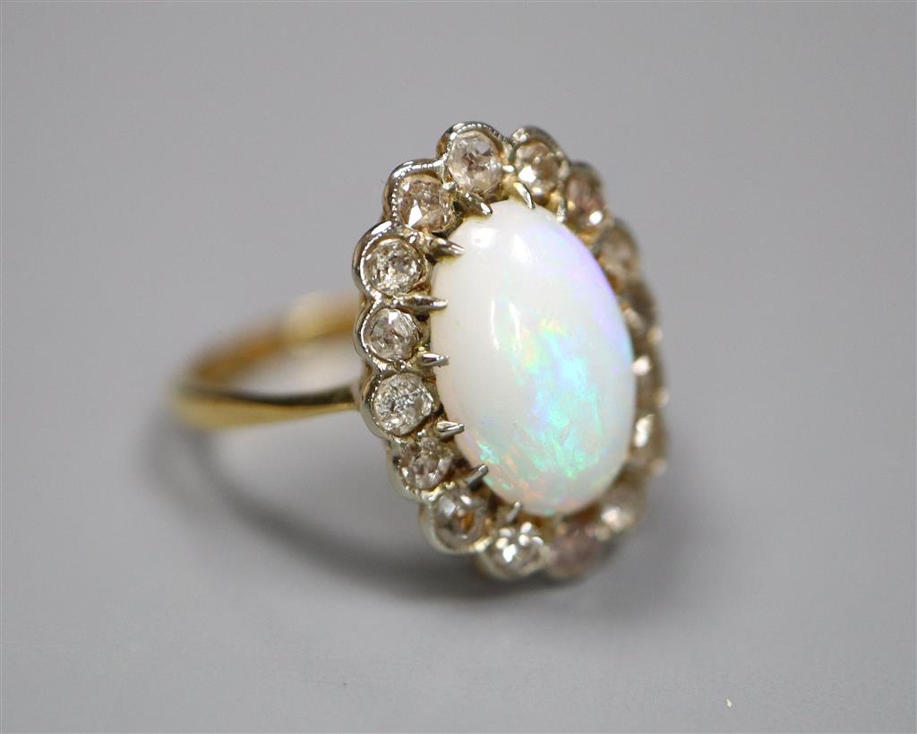An early to mid 20th century 18ct, white opal and diamond set oval cluster ring, size K, gross 3.1 grams.